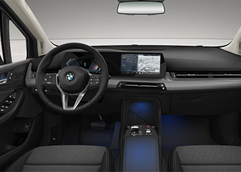 Cockpit eines BMW 2er Active Tourer mit Lenkrad, digitalem Display, Infotainment-Bildschirm und blauer Ambientebeleuchtung.