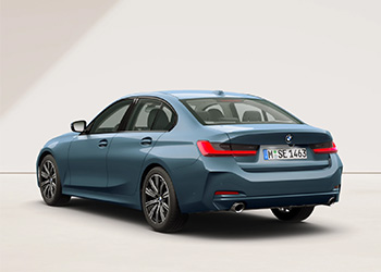 Hellblaue BMW 3er Limousine in schräger Heckansicht vor hellem Hintergrund.