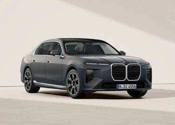 Grauer BMW 7er in Front-Seitenansicht vor hellem Hintergrund.