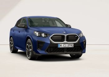 Blauer BMW X2 M35i in Front-Seitenansicht vor hellem Hintergrund.