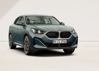 Graugrüner BMW X2 in Front-Seitenansicht vor hellem Hintergrund.