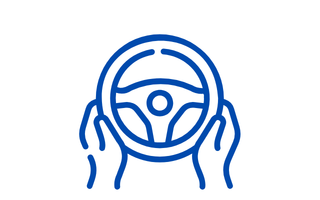 Hände am Lenkrad als Symbol für die Fahrzeugübernahme und den Start der Fahrt.