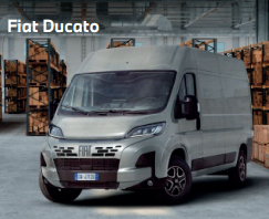 Ein silberner Fiat Ducato steht in einer großen Lagerhalle, umgeben von hohen Regalen voller Holzpaletten und Kartons. Das Fahrzeug ist frontal zu sehen. Oben links im Bild steht der Text „Fiat Ducato“.