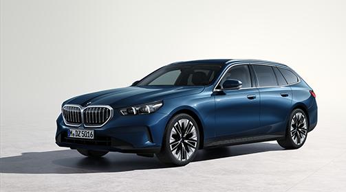 Blauer BMW 5er Touring in Front-Seitenansicht vor hellem Hintergrund.